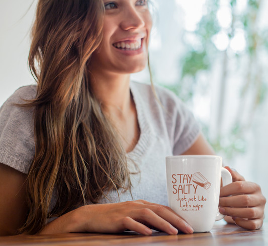 Woman holding a mug with 'Stay Salty' text in a bright indoor setting